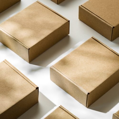 Brown cardboard boxes arranged on a light surface for packing goods in a warehouse setting close up